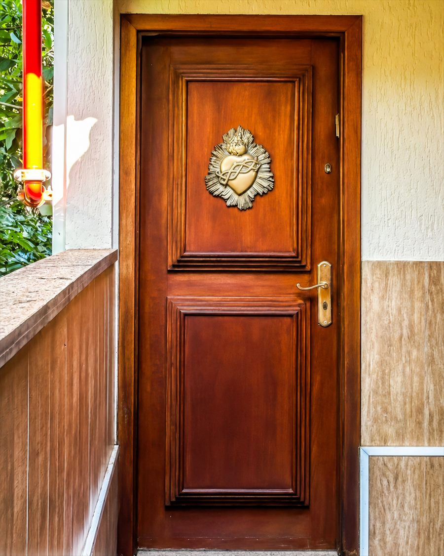 Porta de madeira com um coração em relevo dourado